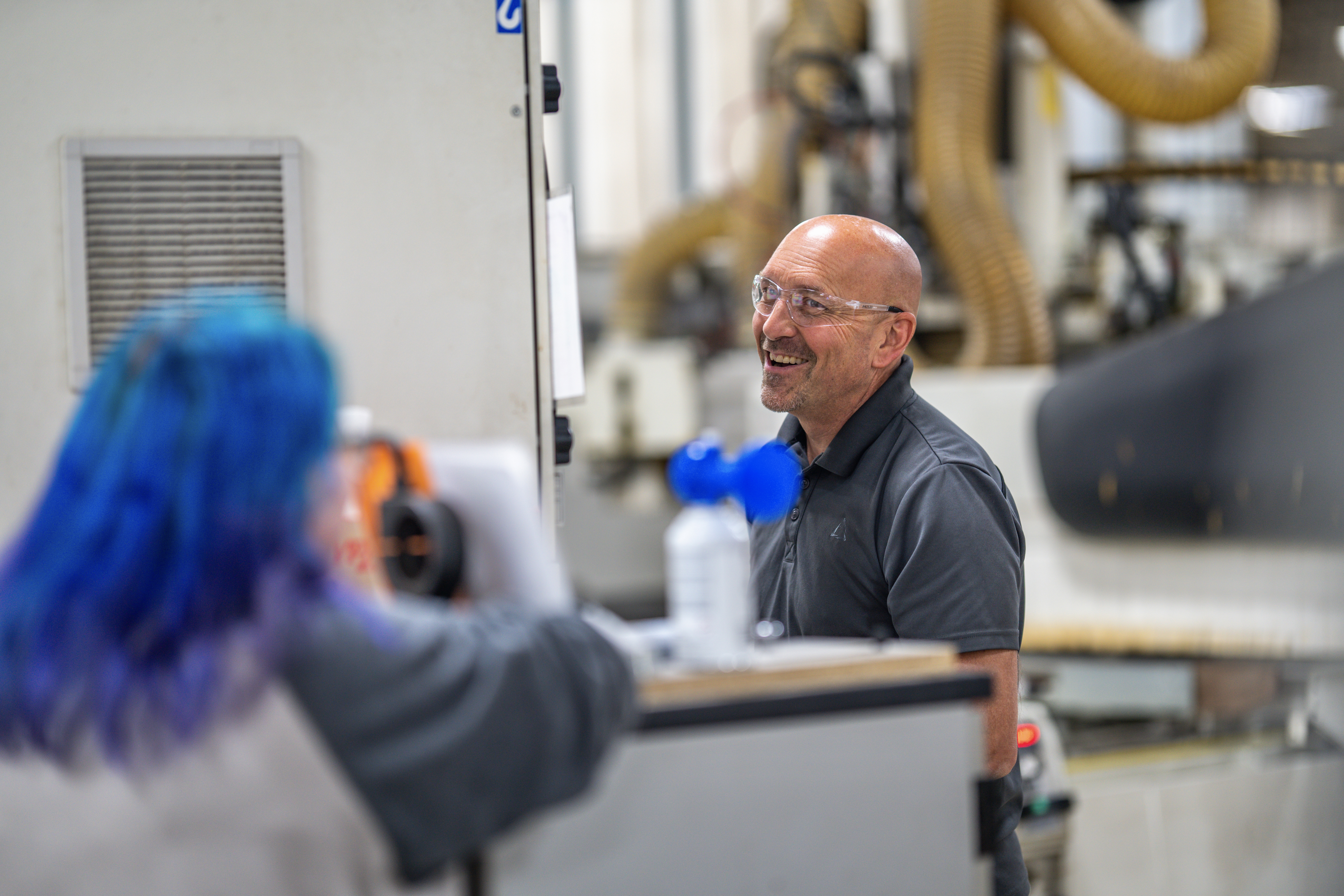 Man talking to woman at machine