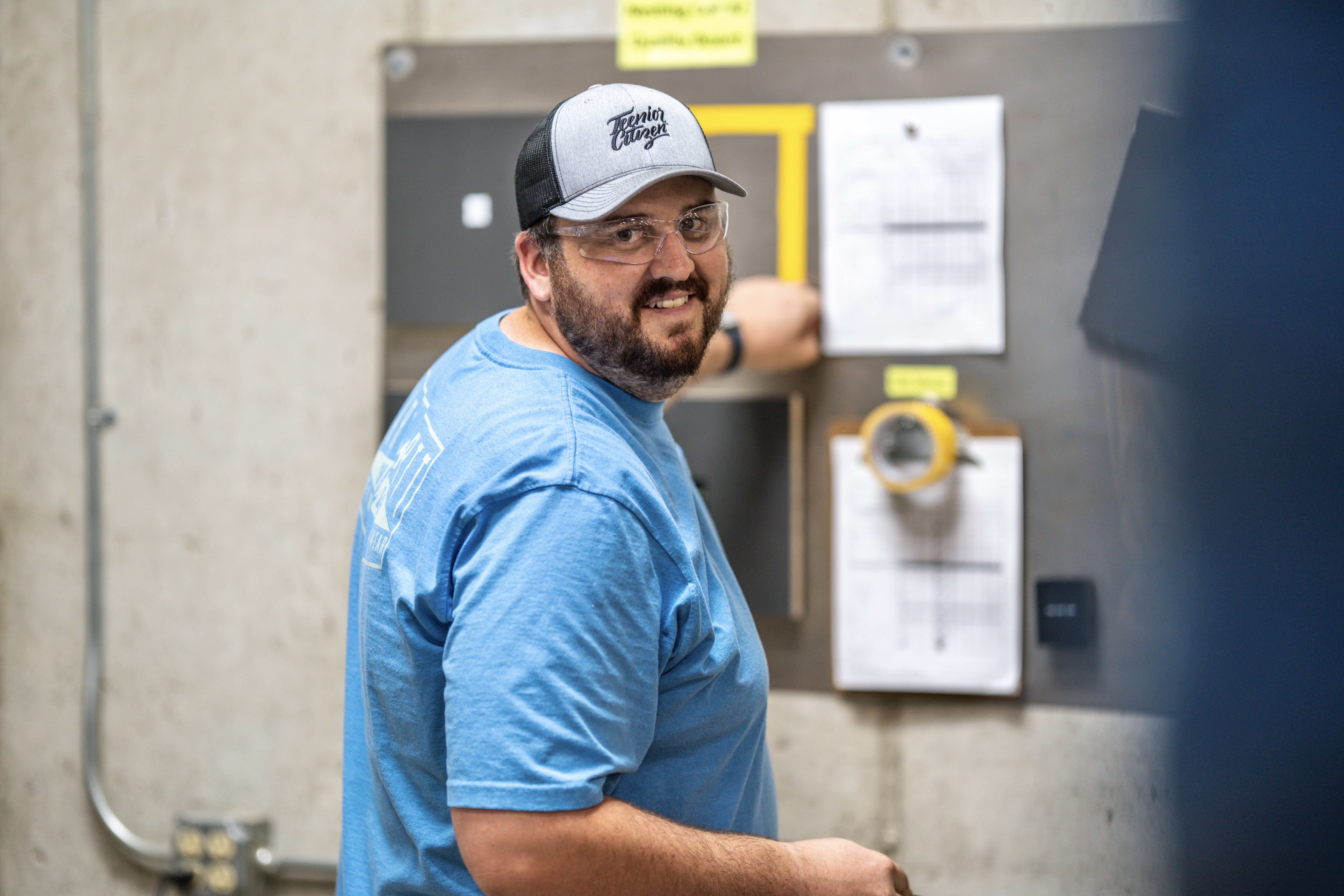 Man on production floor smiling at camera