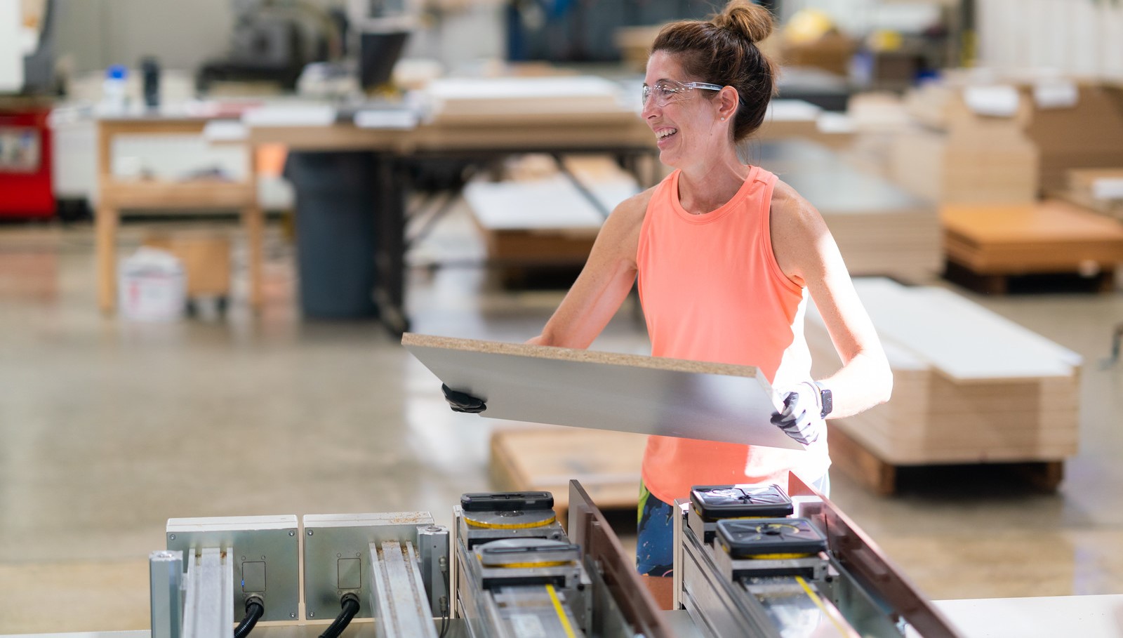 Woman smiling while taking a part off of a machine