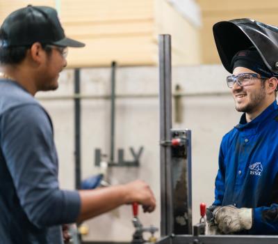 employee talking to welder
